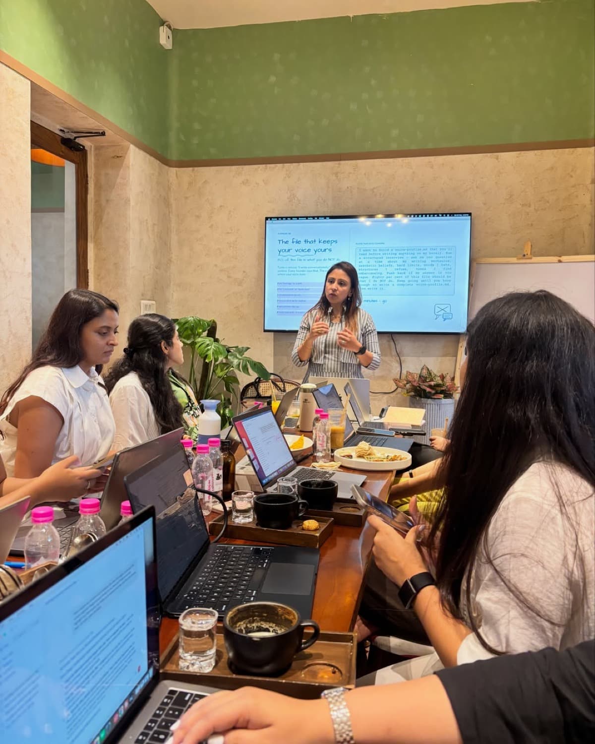 Fatema teaching a session on writing a voice profile, with everyone following on their laptops